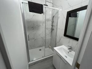 een witte badkamer met een douche en een wastafel bij Appartement Brussels Airport 2 in Machelen