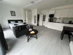 een woonkamer met een bank en een tafel en een keuken bij Appartement Brussels Airport 2 in Machelen