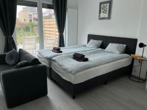 a bedroom with a large bed and a couch at Appartement Brussels Airport 2 in Machelen