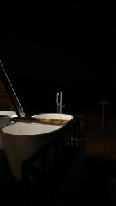 a white sink in a dark room with a cross at Marbella bungalows desert in Bidiyah