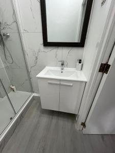 een witte badkamer met een wastafel en een douche bij Appartement Brussels Airport 2 in Machelen