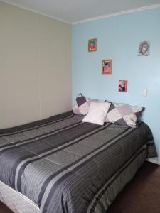 um quarto com uma cama grande e paredes azuis em Arriendo casa muy buena ubicación en Villarrica em Villarrica
