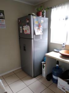 - un réfrigérateur en argent dans une cuisine à côté d'une fenêtre dans l'établissement Arriendo casa muy buena ubicación en Villarrica, à Villarrica