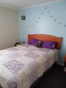 1 dormitorio con 1 cama grande y edredón morado en Arriendo casa muy buena ubicación en Villarrica, en Villarrica