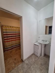 y baño con lavabo y ducha. en Departamento W R T 1 en Villa Carlos Paz