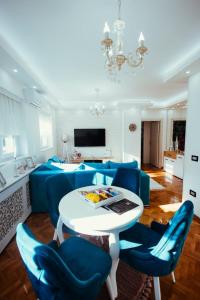 a living room with a blue couch and a table at Apartman Milos free parking in Kraljevo