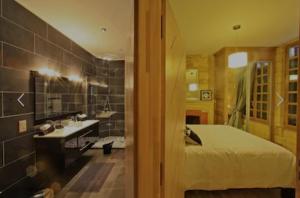 a bathroom with a bed and a sink and a mirror at Appartement de prestige avec parking Sarlat centre in Sarlat-la-Canéda