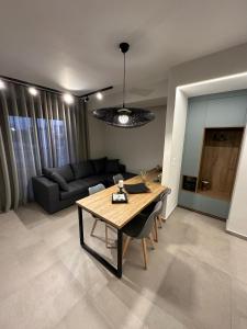 Cozy Apartment in Kalamaria, Thessaloniki في سلانيك: غرفة معيشة مع طاولة وأريكة