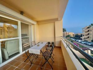 a balcony with a table and chairs on a balcony at 2-Bed Apt with Sea and views near Marbella Spain in Cabopino