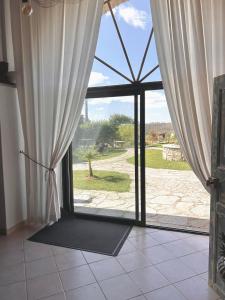 a large glass door with a view of a yard at La demeure des poètes gîtes in Les Cabannes