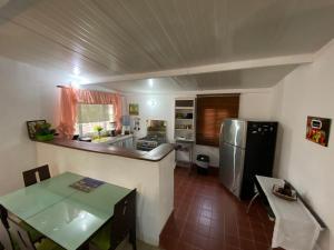 José PobreにあるAeolus Guest Houseのキッチン(ステンレス製の冷蔵庫、テーブル付)