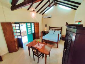 ein Schlafzimmer mit einem Bett, einem Tisch und einem sidx sidx sidx in der Unterkunft The Bungalow Bogmalo An 1880 Indo Portuguese Heritage Beach Villa South Goa in Bogmalo Beach