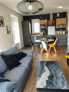 a living room with a blue couch and a kitchen at Maison de Kerangall in Brest