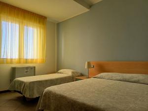 Habitación de hotel con 2 camas y ventana en Hotel Ariston Imperial en Porto Garibaldi