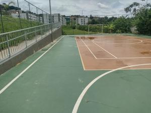 - un court de tennis vide avec un filet dans l'établissement Residencial Versalhes Aluguel barato AP rua santa Terezinha 213, santa cruz , Vespasiano MG, à Vespasiano
