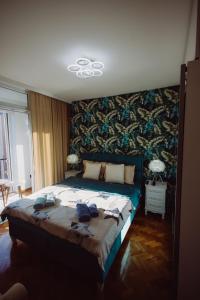 a bedroom with a large bed with a floral wall at Apartman Milos free parking in Kraljevo