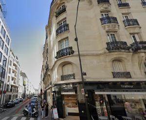 a building on a city street with people walking on the sidewalk at Studio de charme parisien in Levallois-Perret