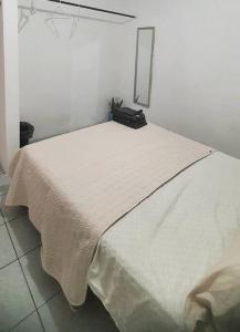 Una cama con una manta blanca encima. en Hermoso Departamento Mi Pueblit0 Mágico., en Palenque