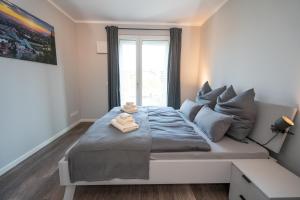 a bedroom with a large bed with a window at Cozy City Dream Apartment mit Terrasse und Parkplatz - 90m² in Dresden