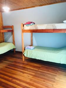 two bunk beds in a room with a wooden floor at Joly in Wanda