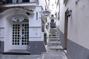 une allée avec une porte blanche et des escaliers dans un bâtiment dans l'établissement La Casa ad Amalfi centro storico, à Amalfi