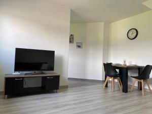 a living room with a tv and a table with chairs at Hradňanka Food&Beer in Predmier