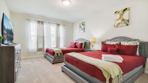 ein Schlafzimmer mit 2 Betten und einem TV in der Unterkunft Magical Mansion 10 Bedroom w pool near Disney in Davenport