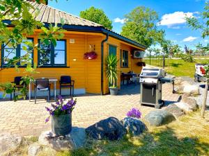 een klein geel huis met een grill ervoor bij Sarpsborg Apartments - Utne Camping in Solli