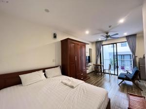 a bedroom with a bed and a chair and a window at Koi Apartment in Da Nang