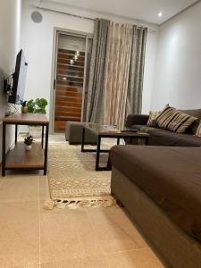 a living room with a couch and a table at Résidence palmerie in El Haouach +16 photos