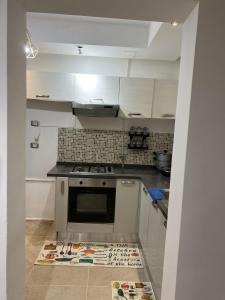 a kitchen with white cabinets and a stove at Résidence palmerie in El Haouach