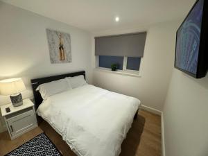 Un pequeño dormitorio con una cama blanca y una ventana en LT Apartment 52 - Free Street Parking, en Leicester