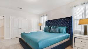 a bedroom with a blue bed with blue pillows at Magical Mansion 10 Bedroom w pool near Disney in Davenport