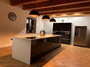 a kitchen with a large island with a black refrigerator at Dworek Willa Biała Góra in Biała Góra