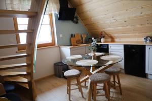 Bańska WyżnaApartamenty Za Wierchem的房间里有一张桌子和凳子的厨房