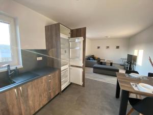 uma cozinha com um frigorífico e uma sala de estar em Hradňanka Food&Beer 