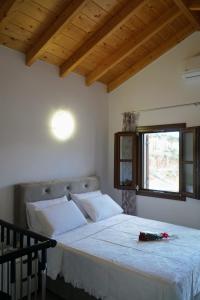 a bedroom with a large white bed with a window at Oceanis apartment in Symi