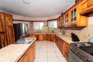 a kitchen with wooden cabinets and a stainless steel refrigerator at Bell Air Seaview (3 BDRM 3 BATH) in Runaway Bay