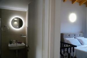 a bathroom with a sink and a bed with a mirror at Oceanis apartment in Symi