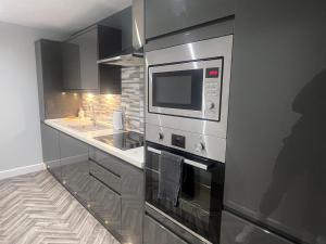 a kitchen with a stove and a microwave at Broadway Retreat with free parking in Herne Bay