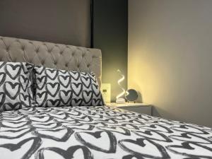 a bedroom with a bed with a black and white comforter at Broadway Retreat with free parking in Herne Bay
