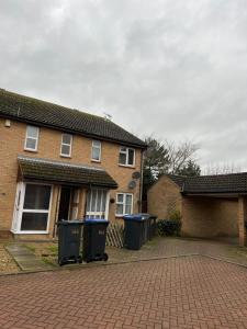 a brick house with two trash cans in the driveway at Broadway Retreat with free parking in Herne Bay