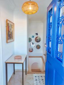 Habitación con puerta azul y mesa en Le Superbe - Sidi Bou Saïd, en Dar Mimoun Bey