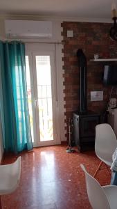 a living room with an open door and a stove at Casa Rural Plaza Zahara Buenas Vistas in Zahara de la Sierra