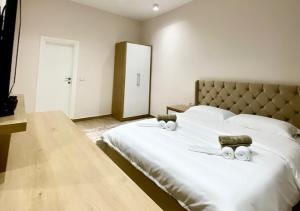 1 dormitorio con 1 cama blanca grande y 2 toallas en Hotel Krial, en Berat