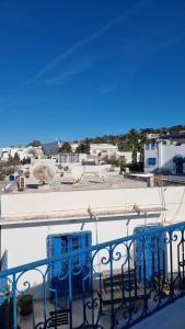 balcón con sillas azules y vistas a la ciudad en Le Superbe - Sidi Bou Saïd en Dar Mimoun Bey