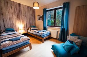 1 dormitorio con 2 camas, silla y ventana en Cze Chill House - Dom na Kaszubach, en Czeczewo