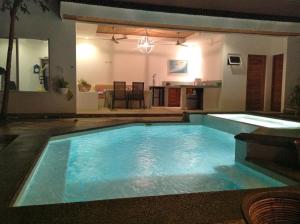 a large swimming pool in a living room with a kitchen at Luxury Beachfront Oasis - Hermosa Palms 50 in Playa Hermosa