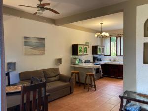 ein Wohnzimmer mit einem Sofa und einer Küche in der Unterkunft Casa Sueno Colibri in Tamarindo