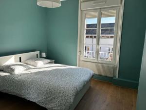 Le Grand' Appart : غرفة نوم زرقاء مع سرير ونافذة